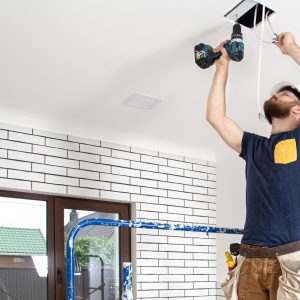 electrician builder work installation lamps height professional overalls with drill repair site scaled e1775497411727.jpg